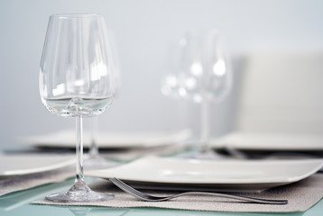 Table setting with a wine glasses, cutlery and plates