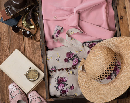 Anticipation of voyage. Women's clothes and accessories in a suitcase.