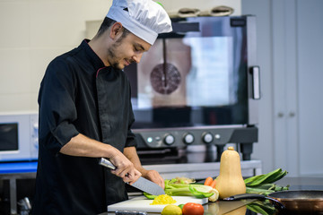 Chef cutting vegetables in a professional kitchen