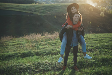 My perfect match. Full length of cheerful female embracing boy neck. They are delighted and happy walking on meadow before sunset. Copy space in left side