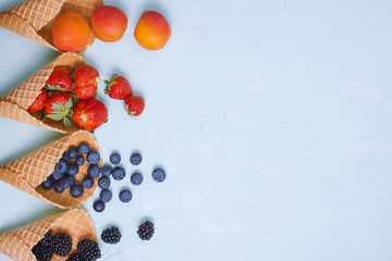 Different berries and fruits on a blue background. Free space for text. Copy space. Flat lay.