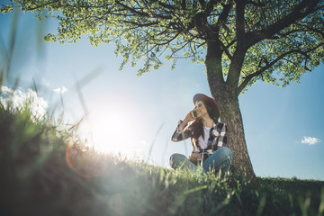 Nice to hear you. Low angle full length of woman having vivid conversation on cellphone. She is happy and excited, surrounded by colourful landscape. Copy space in left side