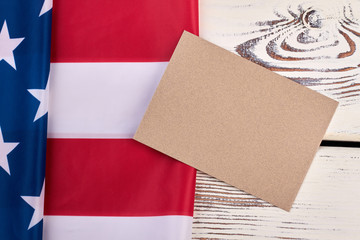 Fototapeta premium American flag on white wooden background. Flag of America and envelope from craft paper on vintage wood.
