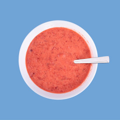 Fresh homemade yogurt, strawberries and sour cream mixed by using blender, little boy blue color background with copy space for text
