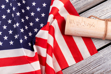 Obraz premium Constitution of the US and USA flag. American flag with rolled-up of constitution document on wooden table.
