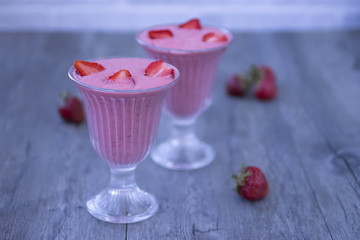Strawberry smoothies in glass glasses on a gray background.