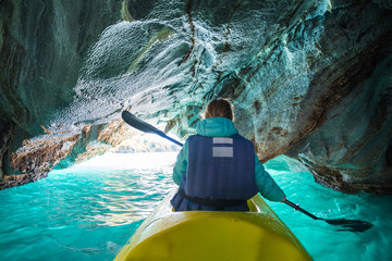 Woman paddles kayak and explores the Marble Caves on the lake of General Carrera, Chile