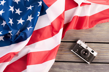 Vintage film camera and USA flag. Old retro camera and national flag of America on wooden...