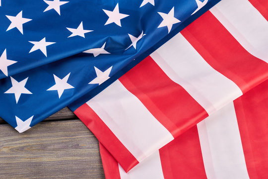 Close up American flag on wooden background. USA patriotic flag folded on wooden surface.
