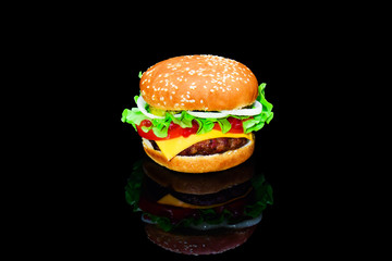 Big tasty hamburger or cheeseburger isolated on black background with grilled meat, cheese, tomato, bacon, onion. Burger closeup