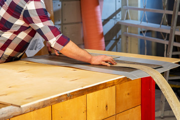 profession, carpentry, woodwork and people concept - carpenter working with wood plank