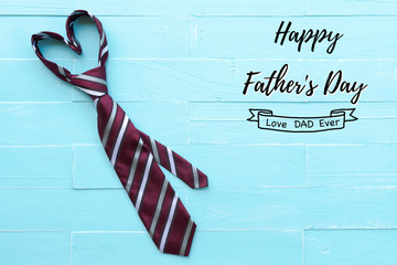 Happy fathers day concept. Red tie in heart shape on bright blue pastel wooden table background.