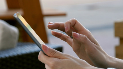 Woman hand using technological tablet device outdoor