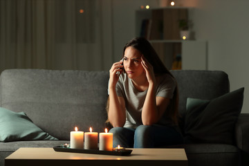 Worried woman talking on phone during blackout
