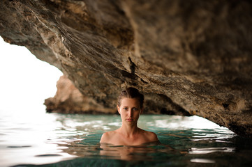 Beautiful young girl with redhead tied hair in the water cave