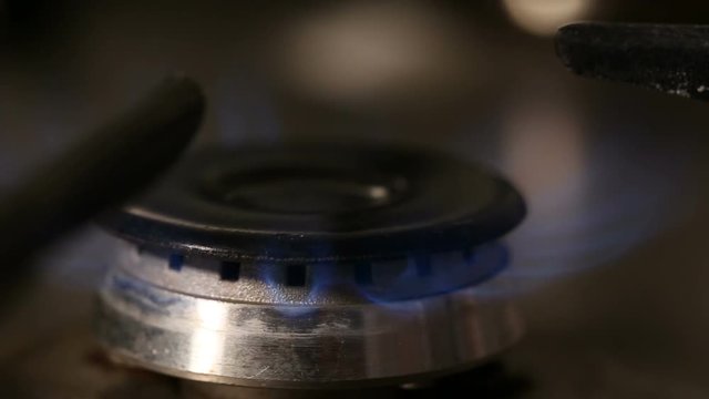 Hand lighting one gas burner - close up view
