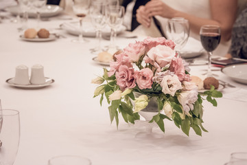Arreglo floral sobre mesa con mantel blanco