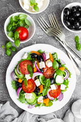 Greek salad. Fresh vegetable salad with tomato, onion, cucumbers, basil, pepper, olives, lettuce and feta cheese. Greek salad on plate
