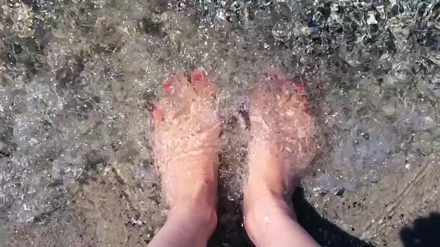 Slow motion video of woman feets in the sea waves