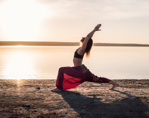 Fototapeta na wymiar Silhouette yoga woman on the beach at sunset. Morning natural training