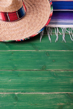 Mexico cinco de mayo fiesta carnival traditional green wood background mexican sombrero and serape rug or blanket photo vertical