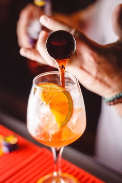 The barman pours Aperol into the cocktail of Aperol Spritz close up