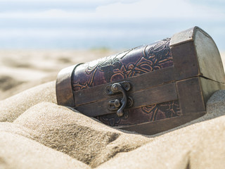 big closed treasure chest on the sea coast in the sand