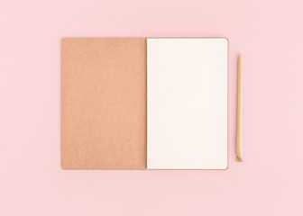 Fototapeta premium Pink desktop with notebook opened page and pen.