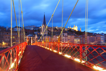 Panoramic view of Saint Georges church and footbridge across Saone river, Old town with Fourviere cathedral during evening blue hour in Lyon, France