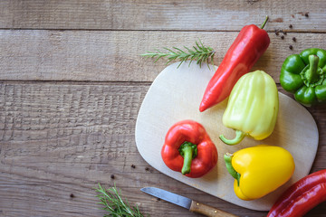 Selection of colorful peppers on wooden table. Cooking fresh food background.