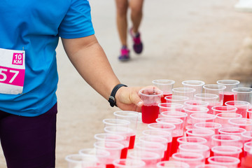 Marathon runner picking up mineral salt water at service point