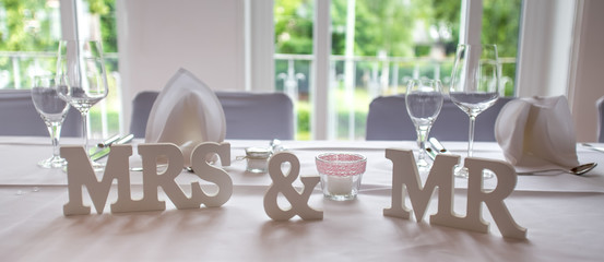 mrs and mr wedding signs on a plain table