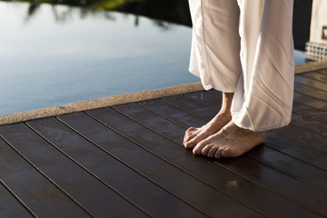 Senior adult practicing yoga by the pool