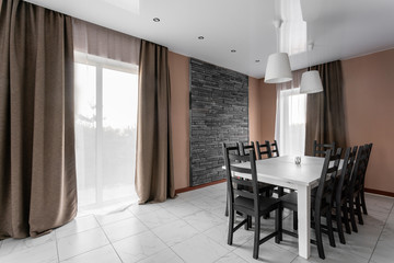 dining table for ten people. Modern minimalism style drawing-room interior. Simple and inexpensive living room with kitchen. daylight in the morning