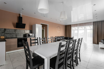 dining table for ten people. Modern minimalism style drawing-room interior. Simple and inexpensive living room with kitchen. daylight in the morning