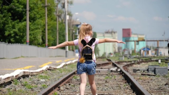 Little girl walking on the railway.