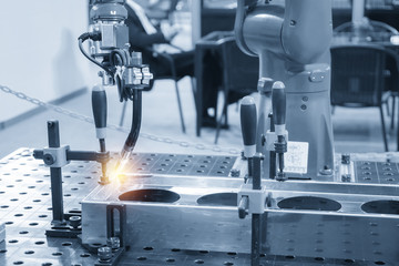 The welding robot machine for welding automotive part in the light blue scene.Industrial 4.0...