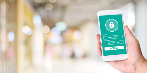 Hand using smartphone with password login on screen over blur background, cyber security concept