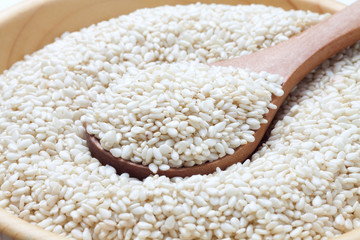 White sesame seeds with wooden spoon in a bowl
