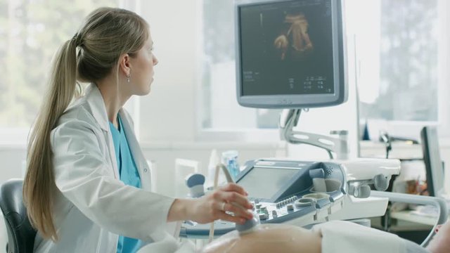 In the Hospital, Obstetrician Uses Transducer for Ultrasound/ Sonogram Screening / Scanning Belly of the Pregnant Mother. Shot on RED EPIC-W 8K Helium Cinema Camera.