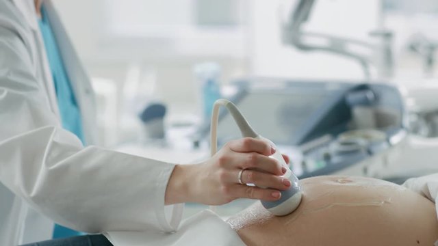 In the Hospital, Pregnant Woman Getting Sonogram / Ultrasound Screening / Scan, Obstetrician Checks Picture of the Healthy Baby on the Computer Screen. Shot on RED EPIC-W 8K Helium Cinema Camera.