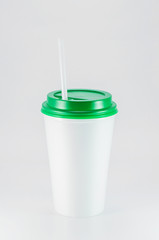 white plastic coffee cup with green lid on white background, view from above with copy space