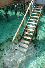 Stair down to crystal clear ocean from water villa private balcony, Maldives