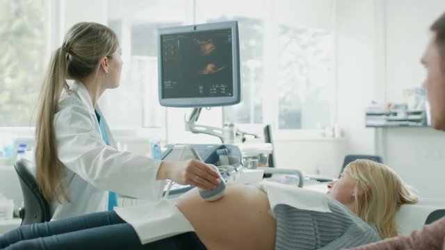 In the Hospital, Pregnant Woman Getting Ultrasound / Sonogram Scan, Obstetrician Explains Procedure to Her and Her Supportive Husband. Shot on RED EPIC-W 8K Helium Cinema Camera.