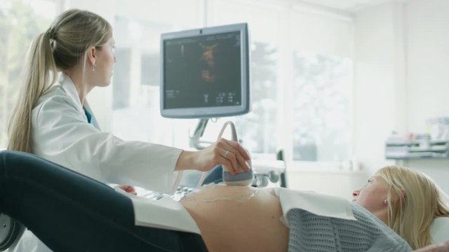 In the Hospital, Obstetrician Uses Transducer for Ultrasound/ Sonogram Screening / Scanning Belly of the Pregnant Woman. Shot on RED EPIC-W 8K Helium Cinema Camera.