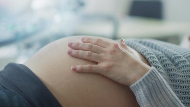 Close-up of the Pregnant Woman's Belly while She's Stroking and Touching it with Her Hand