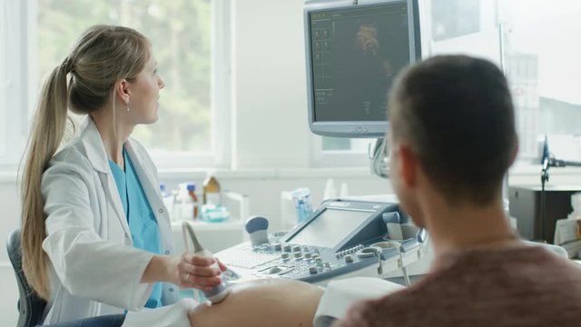 In the Hospital, Female Obstetrician Puts Gel on the Belly of a Pregnant Mother, Ready to do Ultrasound Screening. Happy Family. Shot on RED EPIC-W 8K Helium Cinema Camera.