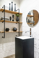 Stylish wooden bathroom with round mirror and countertop basin