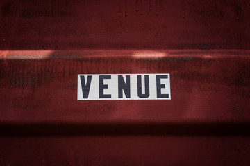 Black and white Venue sign on red background