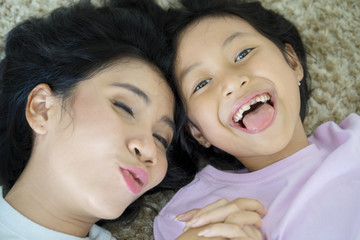 Child and mother lying together on the carpet